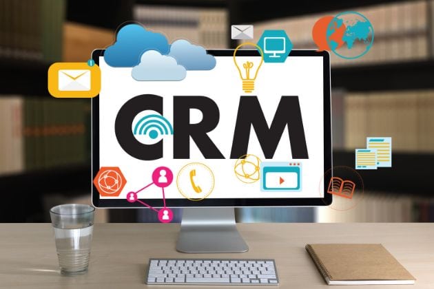 large texte CRM sur un ecran d’ordinateur posé sur un bureau